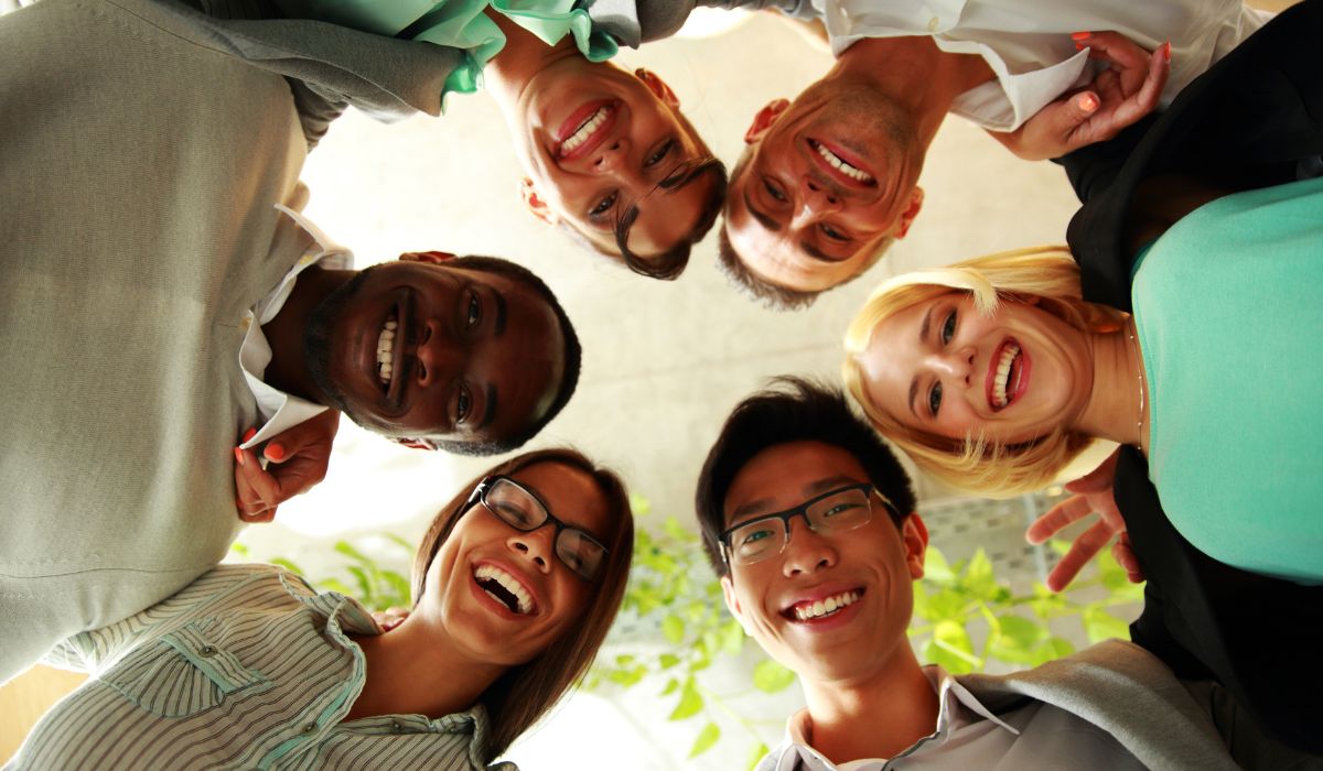 Group of smiling friends looking down at the camera
