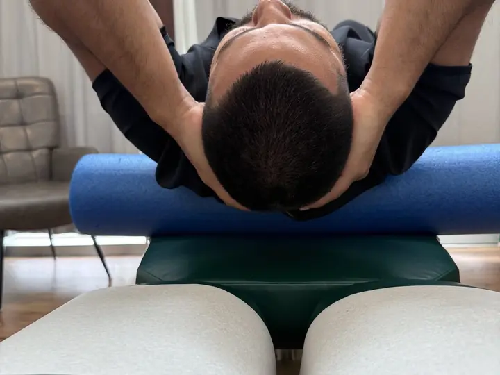 Foam Roller Thoracic Extension: Setup: hands behind the head, roller below the shoulder blades