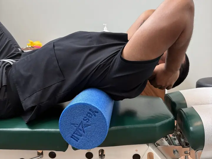 Foam Roller Thoracic Extension: Side view: upper back drapes over the roller